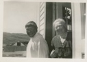 Image of Mrs. Paul Hettasch in doorway of her home, with Eskimo [Inuk] man